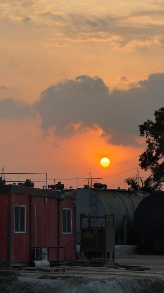 pexels photo 35224903 Industrial site with storage tanks at sunset, casting a warm glow in the sky.